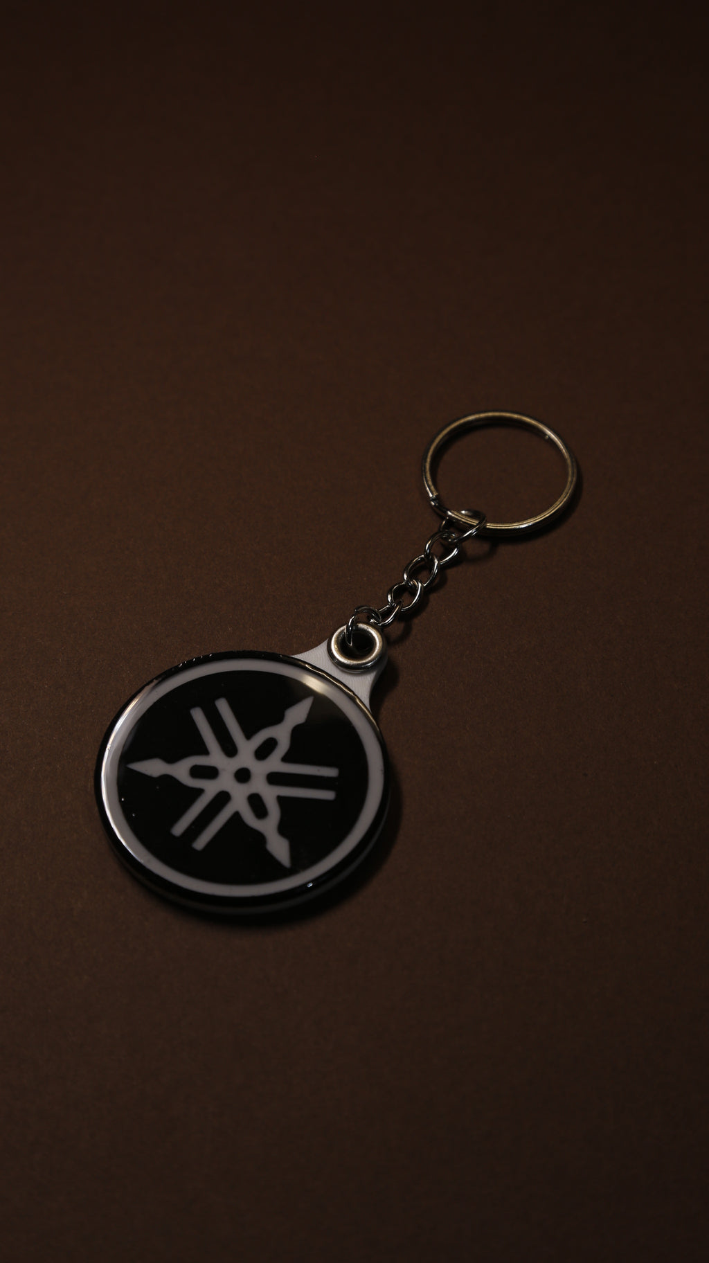 Close-up of the Yamaha tuning fork keychain showing the hand-finished gloss