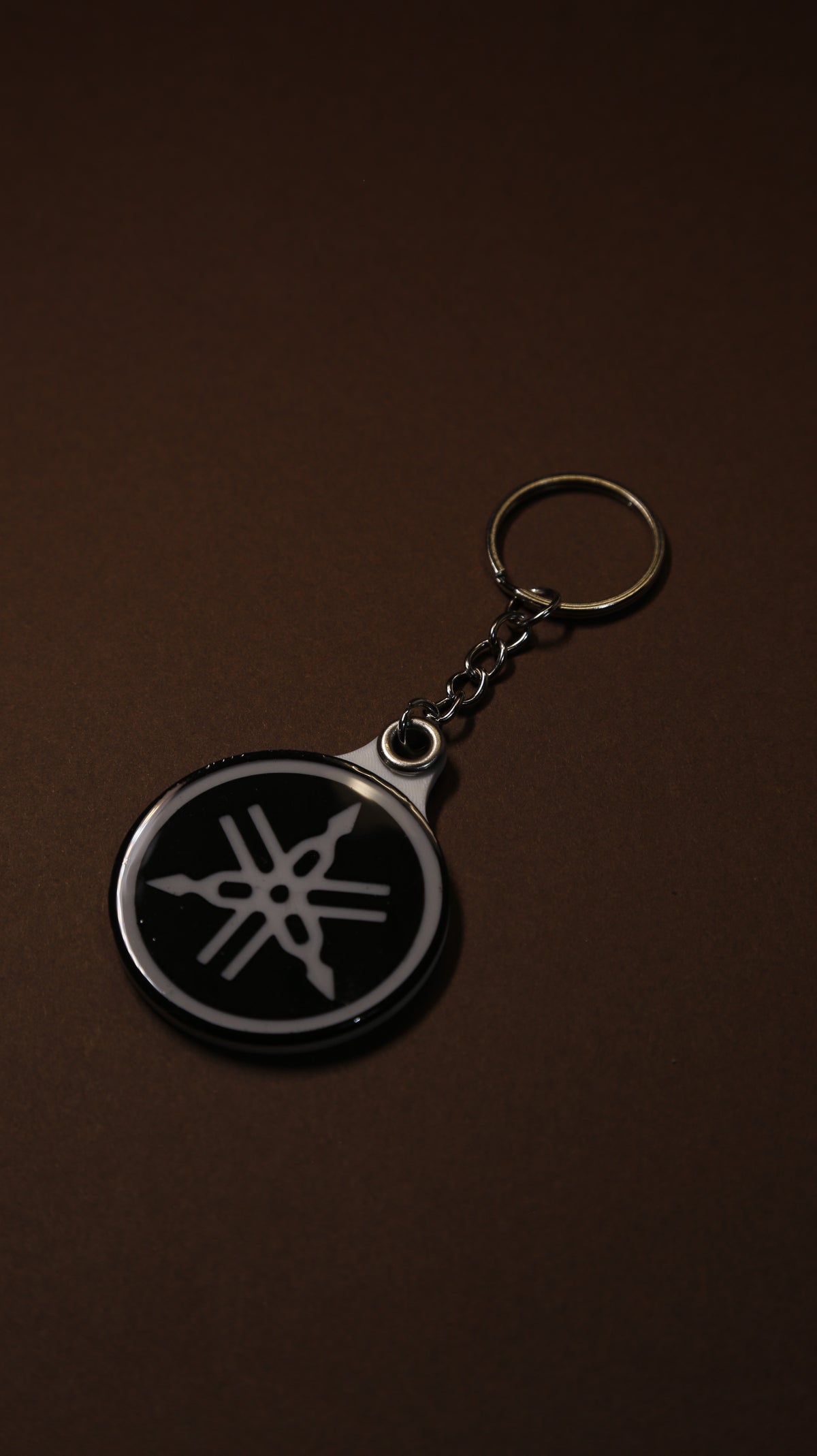 Close-up of the Yamaha tuning fork keychain showing the hand-finished gloss