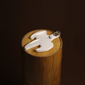 Koenigsegg ghost keychain in black and white, close-up of the emblem