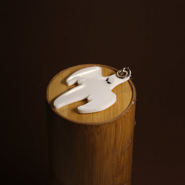 Koenigsegg ghost keychain in black and white, close-up of the emblem