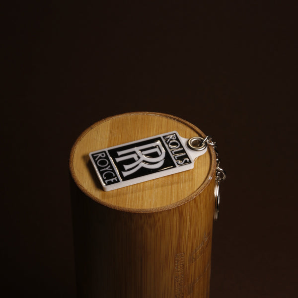 Close-up of the Rolls-Royce monogram keychain showing the acrylic finish