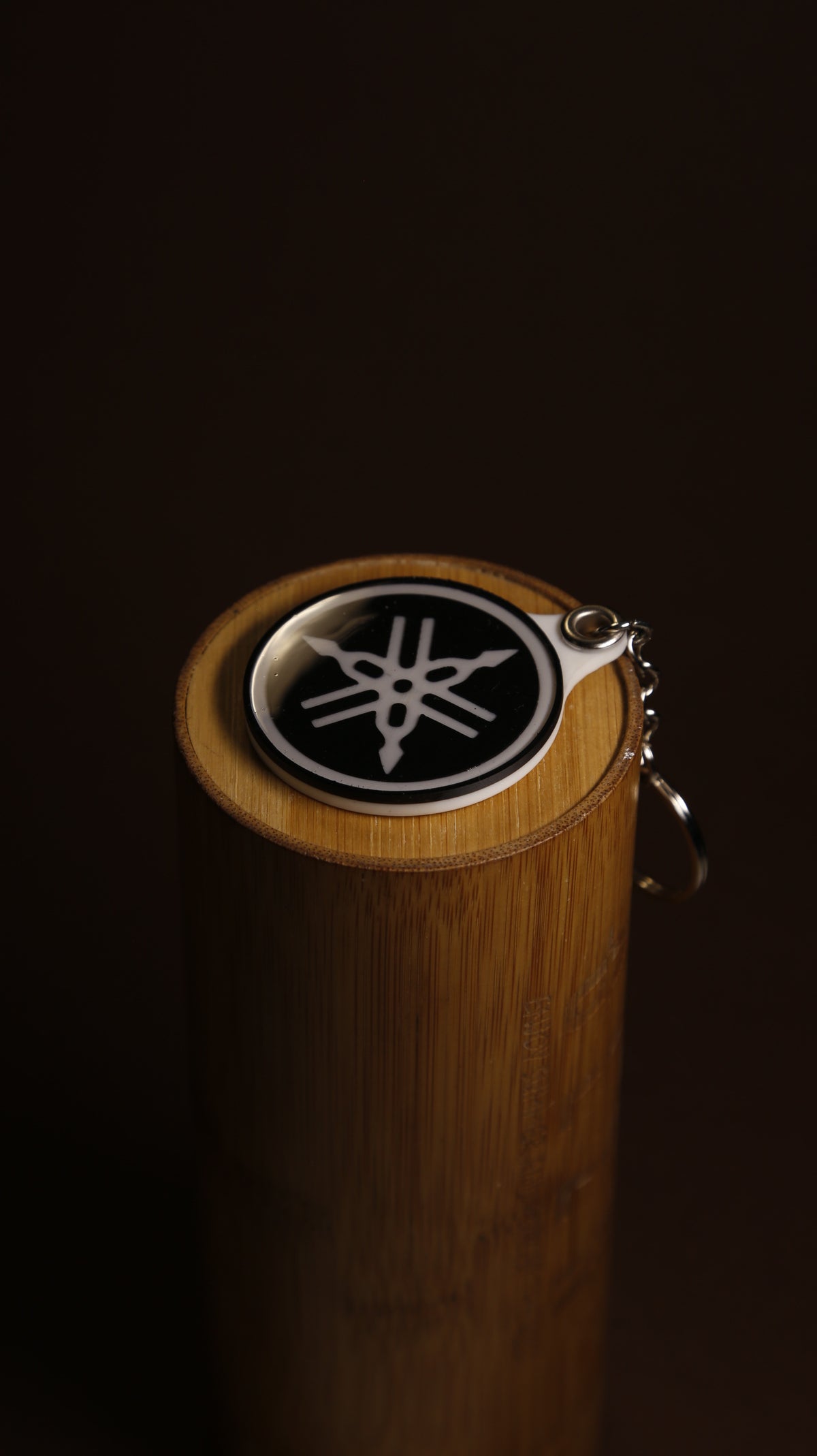 Yamaha tuning fork emblem keychain in acrylic on a plain background