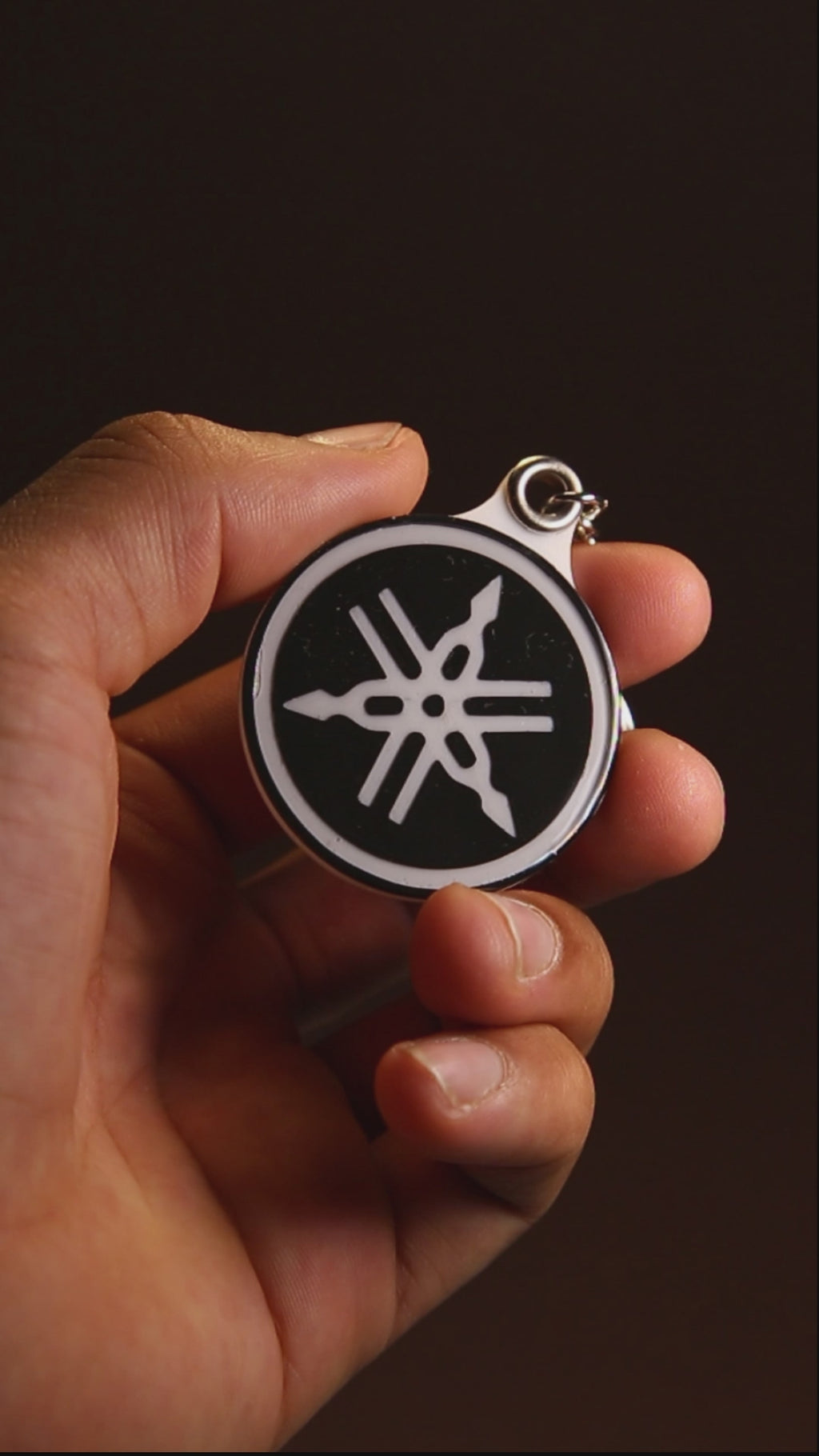 Yamaha tuning fork keychain turning to show its acrylic finish