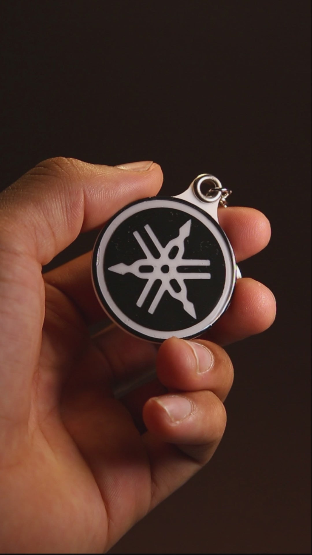 Yamaha tuning fork keychain turning to show its acrylic finish